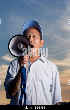 Close-up di un anziano uomo grida in un megafono Foto Stock
