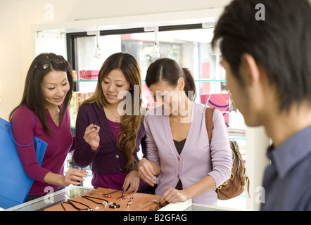 Vista di un giovane uomo che guarda le donne in un negozio Gioielli Foto Stock