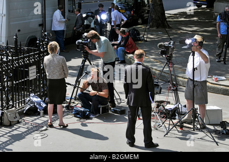 Attraversata la strada dalla Corte reale di giustizia giurisprudenza giornalisti e giornalisti con telecamere TV equipaggi file loro notizie relazioni Foto Stock