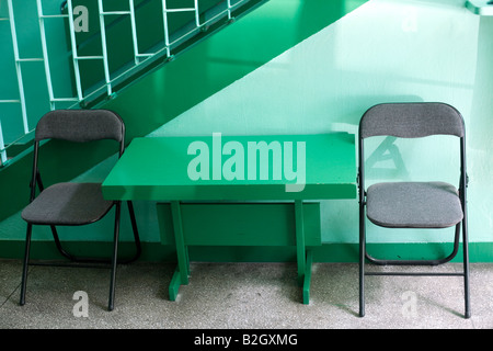 Due sedie pieghevoli e un tavolo in una camera verde. Foto Stock