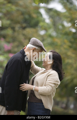Il profilo laterale di una donna senior abbracciando un uomo anziano Foto Stock