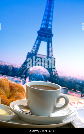 Parigina tipica colazione continentale del caffè, croissant e burro sul tavolo con la Torre Eiffel sullo sfondo Parigi Francia Foto Stock