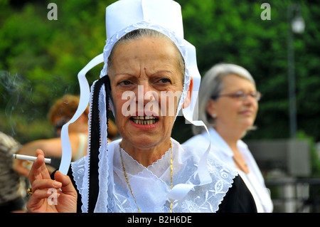 Ritratto di una vecchia donna in costume tradizionale di fumare sigarette festival di Cornovaglia a Quimper 2008 Foto Stock