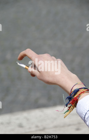 Dettaglio uomo adolescente holding sigaretta in città Foto Stock