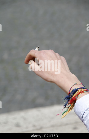 Dettaglio uomo adolescente holding sigaretta in città Foto Stock