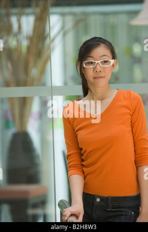 Giovane donna in piedi vicino a una ringhiera, Singapore Foto Stock
