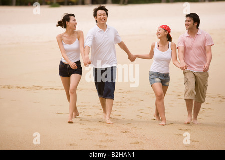 Due giovani coppie di camminare sulla spiaggia Foto Stock