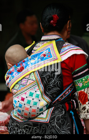 Yi donna e bambino al mercato del bestiame a Yuanyang, Yunnan in Cina. Foto Stock