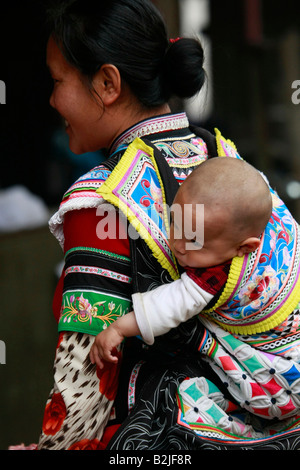 Yi donna e bambino al mercato del bestiame a Yuanyang, Yunnan in Cina. Foto Stock