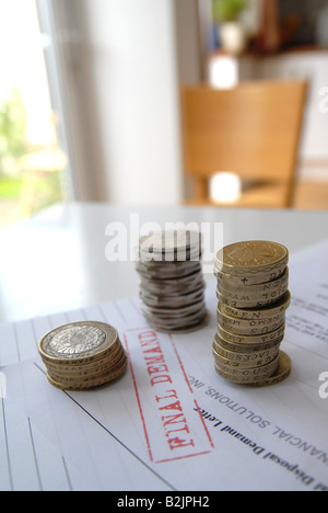 Una pila di monete che vengono contati, cercando di pagare le bollette / domanda finale promemoria / rosso / bill. Foto Stock