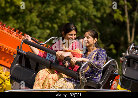 Regno Unito Inghilterra Manchester Platt Fields Mega Mela shalwar kameez indossando donne pakistane su Fairground Ride Foto Stock