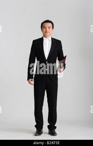 Ritratto di un maschio di fortune teller tenendo un cinese feng shui bussola Foto Stock