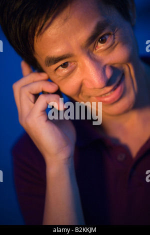 Ritratto di una metà uomo adulto utilizzando un telefono cellulare Foto Stock