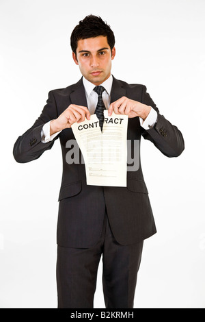 Un uomo in una tuta la lacerazione di un contratto. Foto Stock