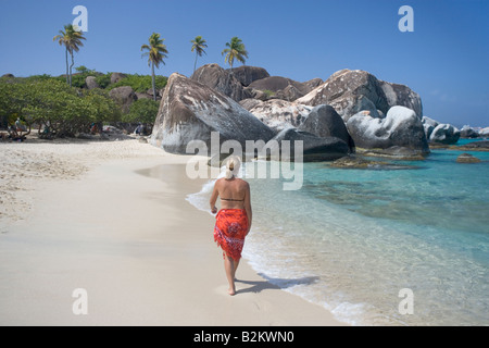 Una donna in vacanza passeggiate sulla spiaggia vicino alle terme su Virgin Gorda BVI Foto Stock