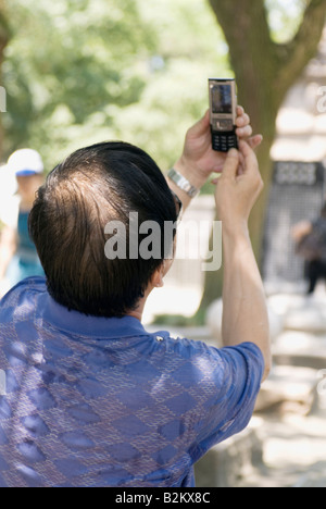 Uomo cinese di scattare una foto con il suo telefono cellulare, Cina, Suzhou, la Collina della Tigre Foto Stock