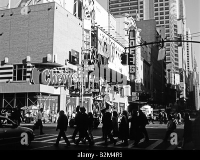 Silhouette di persone che camminano attraverso l'incrocio, Street Scene, West 42nd Street, 8th Avenue, Manhattan, New York, New York state, Stati Uniti Foto Stock