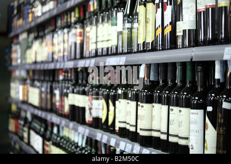 Le bottiglie di vino in una fila di messa a fuoco selettiva Foto Stock