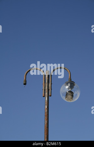 Danneggiato street lampada posta all'aperto in sun Foto Stock
