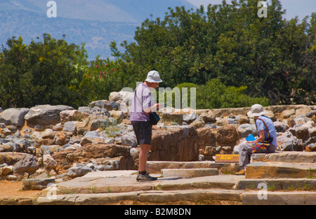 I turisti in cerca di rovine del palazzo minoico distrutto da un incendio nel 1450 BC a Malia sul Greco isola mediterranea di Creta Foto Stock