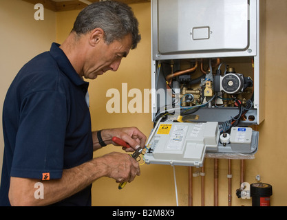 Uomo al lavoro su una caldaia a gas Foto Stock