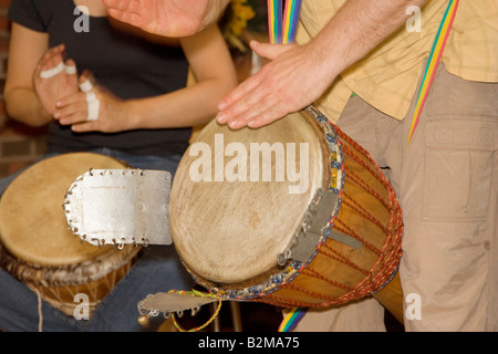 Due uomini giocando djembe, un tamburo africano Foto Stock