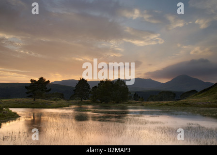 Luce della Sera e di riflessione in tarda serata la luce a Kelly Hall Tarn vicino a Coniston nel Lake District inglese Foto Stock