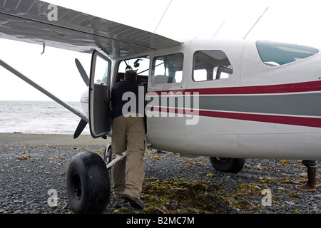 Controllo pilota il suo aereo su una spiaggia di Katmai Park e preservare, Alaska Foto Stock