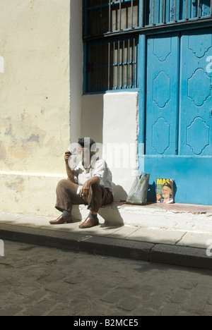 Uomo seduto tubo di fumo nella zona vecchia della città dell Avana, Cuba. Foto Stock