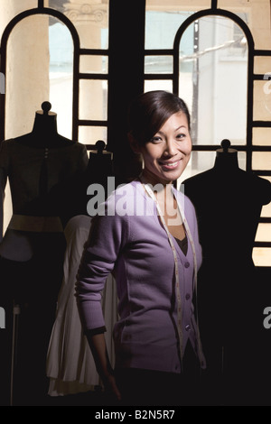 Ritratto di un sorridente metà donna adulta in piedi da manichini Foto Stock