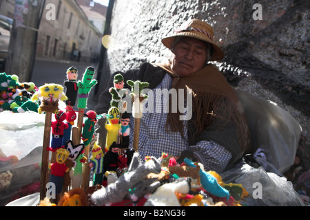 Un locale donna boliviana vendita di dito fantoccio vicino al mercato delle streghe a La Paz, in Bolivia. Foto Stock