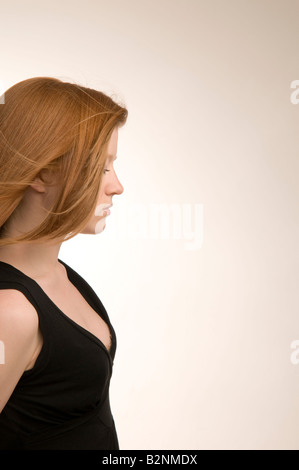 A lungo dai capelli rossi diciannovenne slim ragazza adolescente in profilo cerca da solo di carattere introverso e triste e depresso Foto Stock