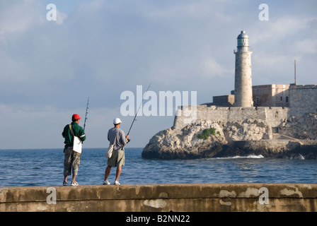 Gli uomini la pesca di fronte al faro di Morro Castle Havana Cuba Foto Stock