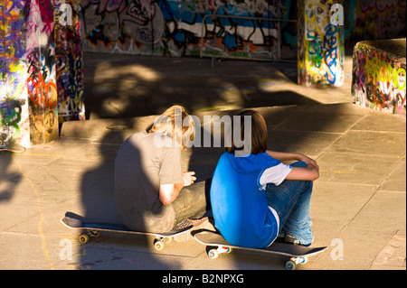 Due adolescenti pattinatori rullo resto Southbank SE1 London Regno Unito Foto Stock