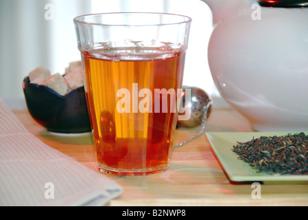 Bicchiere di tè caldo, allentato con foglie di tè nero Foto Stock