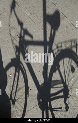 Una bicicletta ombra sul marciapiede strada in sun Foto Stock