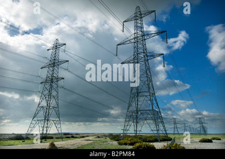 Tralicci di energia elettrica Potenza di trasporto da parte di British Energy Dungeness B Centrale Nucleare attraverso la campagna del Kent Foto Stock