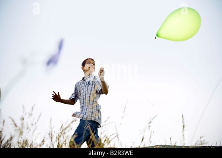 Ragazzo in esecuzione con palloncino Foto Stock