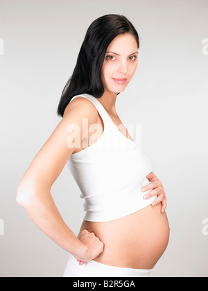 Donna incinta toccando il suo stomaco Foto Stock