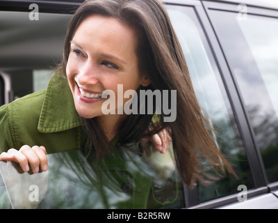 Donna che passa la sua testa fuori della vettura Foto Stock