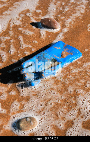 Un blu guanto di gomma lavata fino sulla spiaggia. Foto Stock