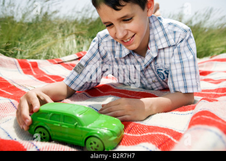 Ragazzo giocando con verde auto giocattolo Foto Stock