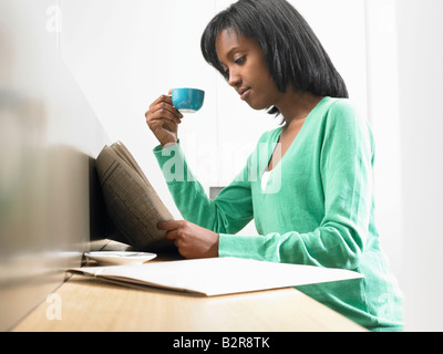 Donna con un caffè, quotidiano di lettura Foto Stock