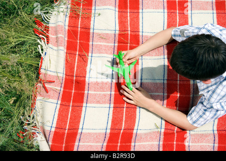 Ragazzo giocando con il giocattolo verde piano Foto Stock