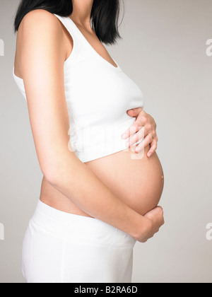 Donna incinta toccando il suo stomaco Foto Stock