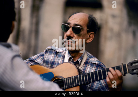 Uomo con occhiali da sole a suonare la chitarra a l'Avana, Cuba Foto Stock