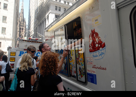 Ice Cream amanti godono di un cono di gelato morbido a partire da un Mr Softee carrello su Wall Street a New York Foto Stock