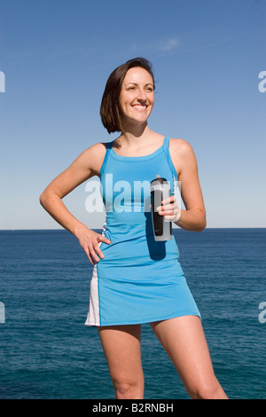 Femminile in vestito blu con una bottiglia d'acqua Foto Stock