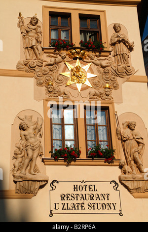 La facciata dell'Hotel "U Zlate Studny" decorata con statue e fiori situato sulla via Karlova di Praga Foto Stock