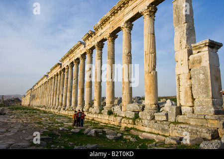 Ragazzi locali e la Collonade presso le rovine Romane di Apamea in Siria Foto Stock